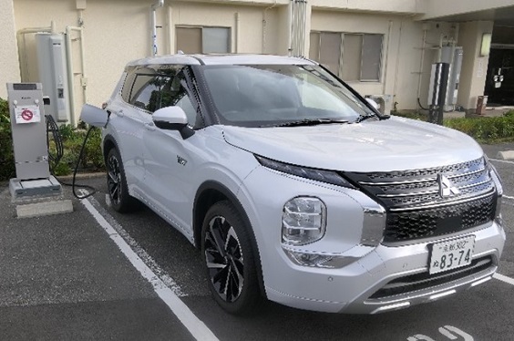 太陽光パネル（写真左）で発電した電気をプラグインハイブリッドEV『アウトランダー』に充電