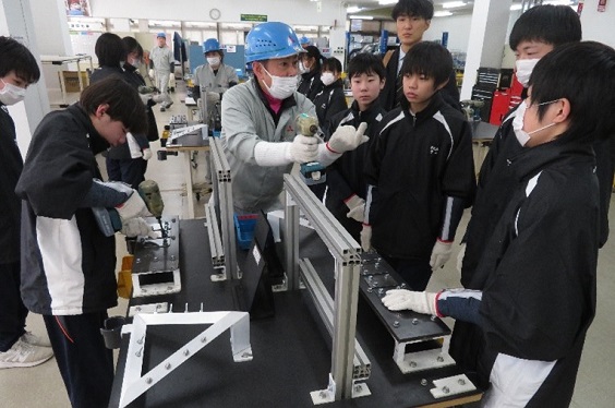 電動工具の使い方のレクチャーを受ける様子